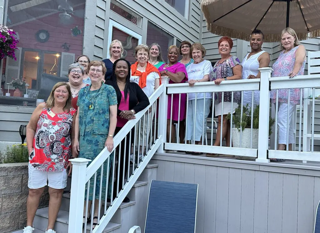 Group of women posing on outdoor stairs.