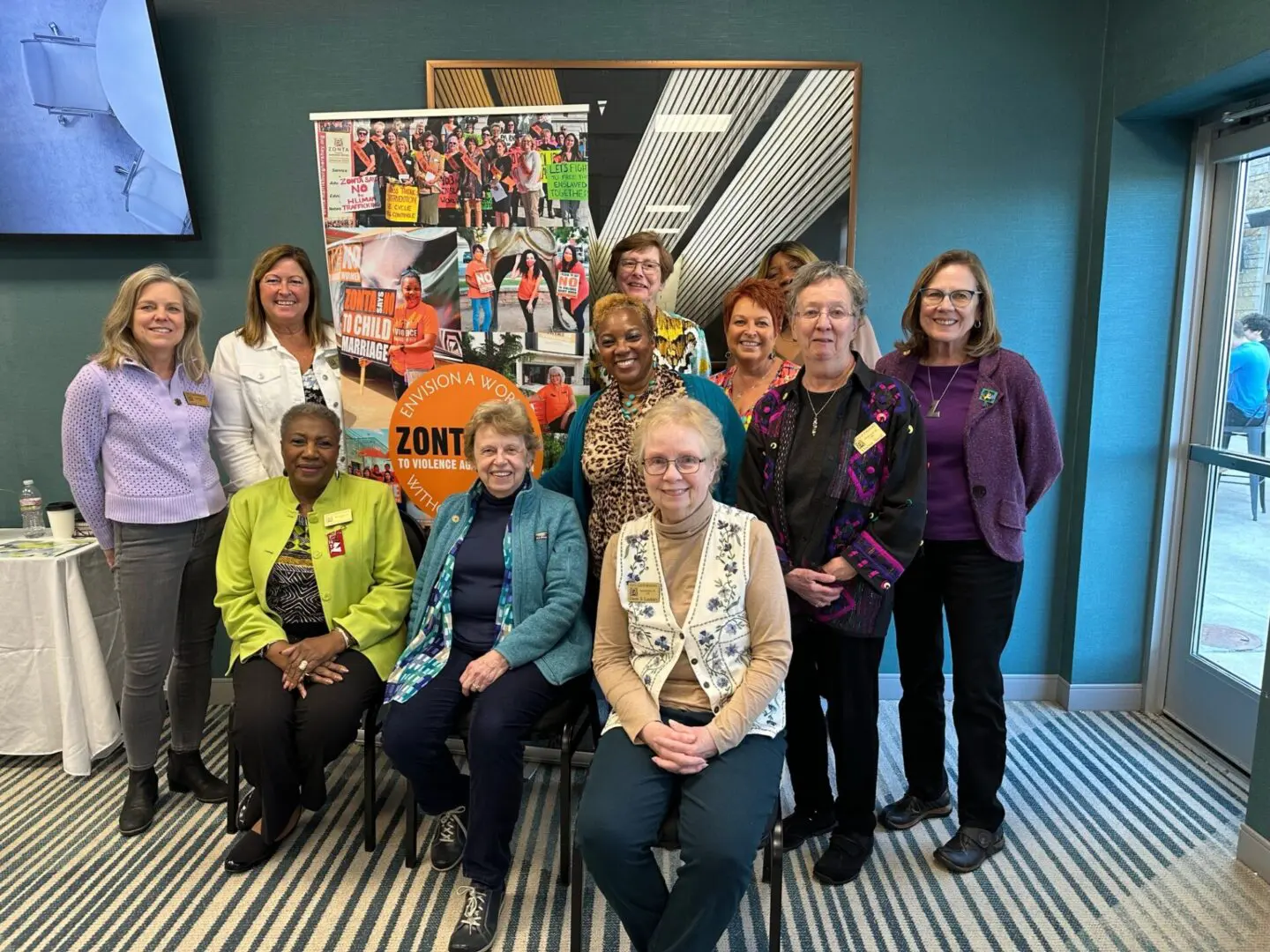 Group of people posing indoors, smiling.